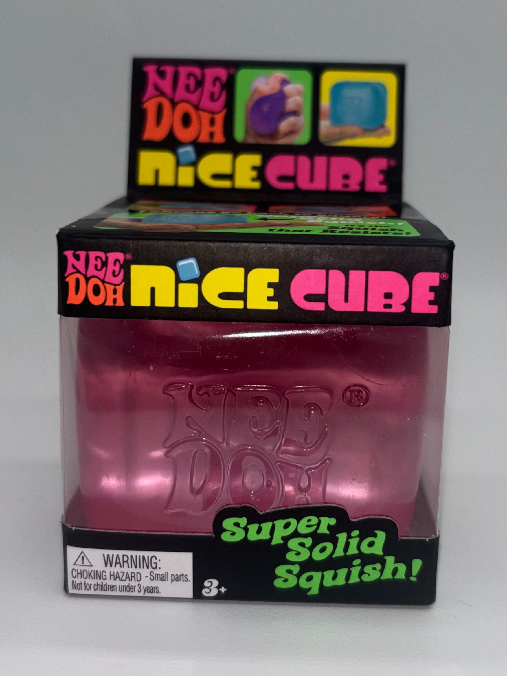 Pink NeeDoh Nice Cube toy with colorful packaging on a white background
